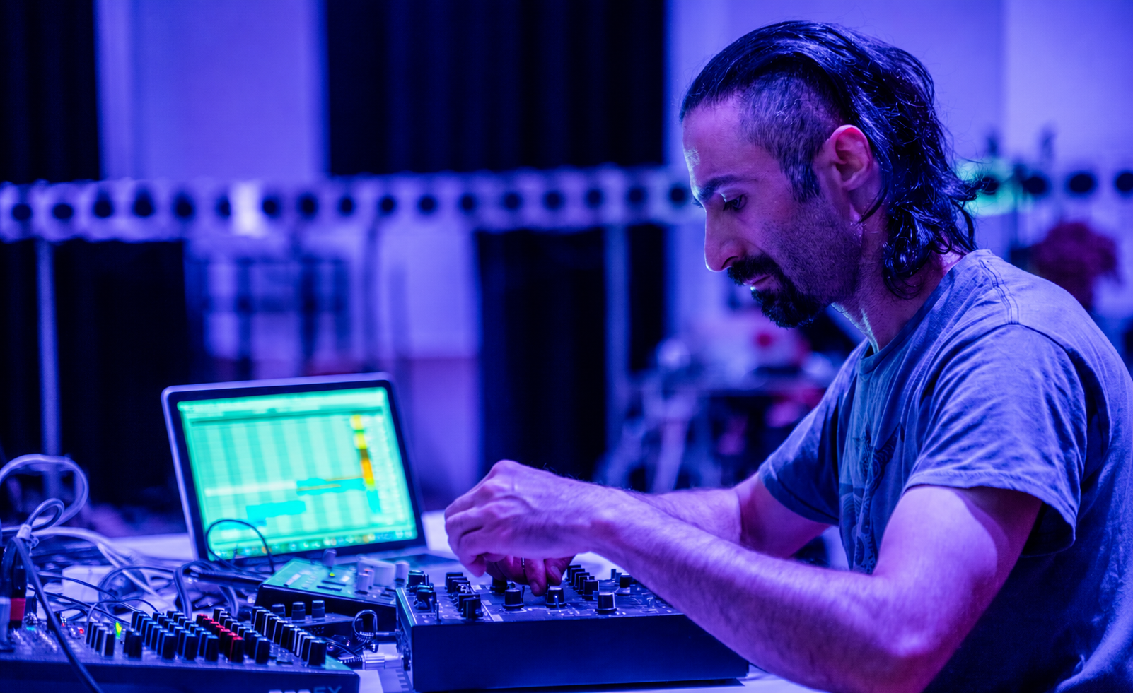 Soheil Soheili operating audio equipment during a live experimental music performance